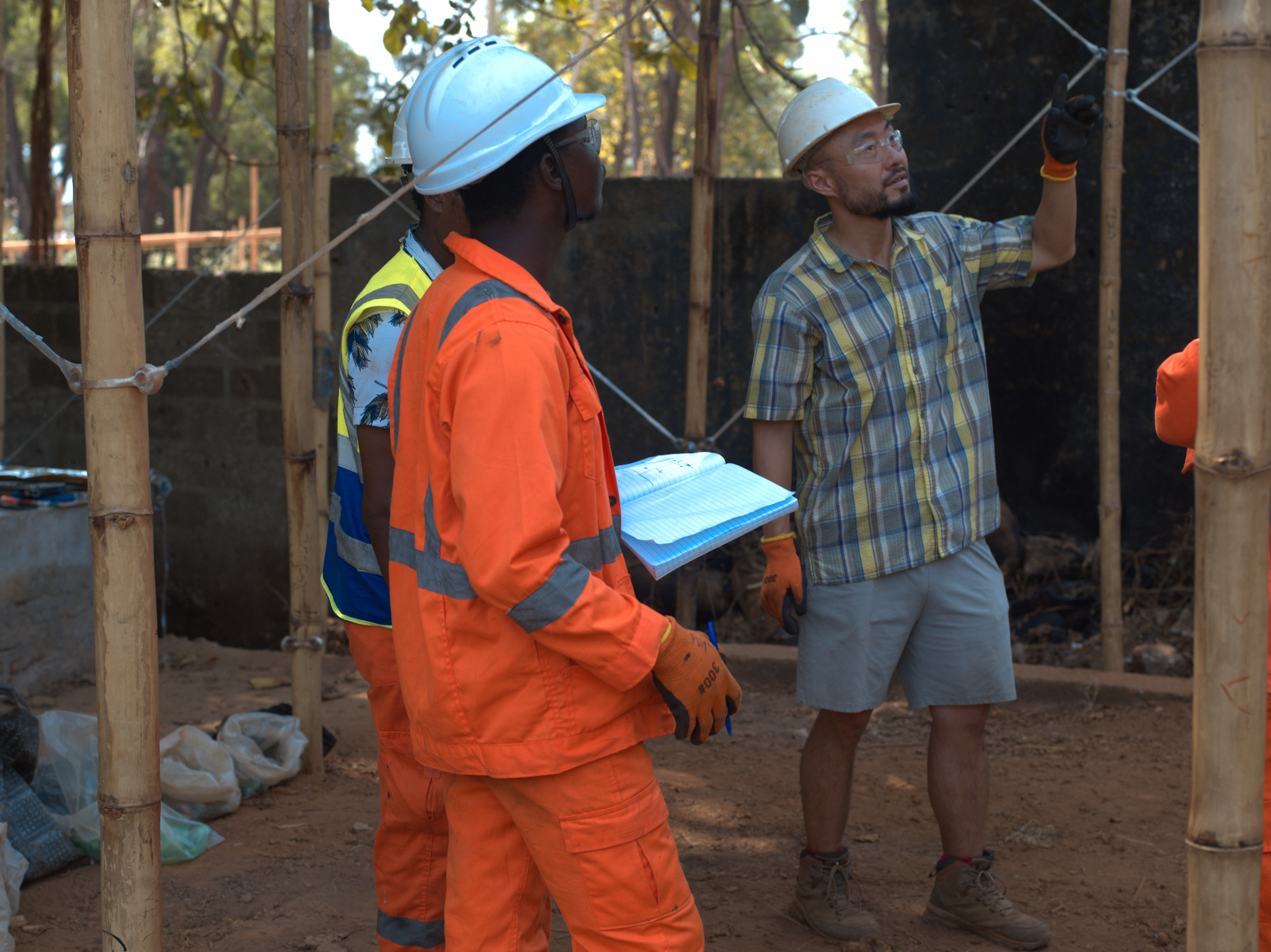 Dr Ye Tao and local engineers reviewing plans at a field deployment site in Sierra Leone