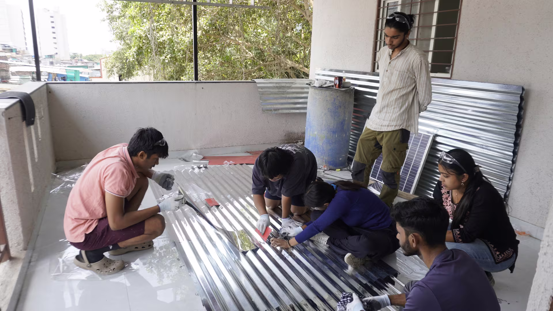 Intern preparing reflective aluminium sheeting in Pune