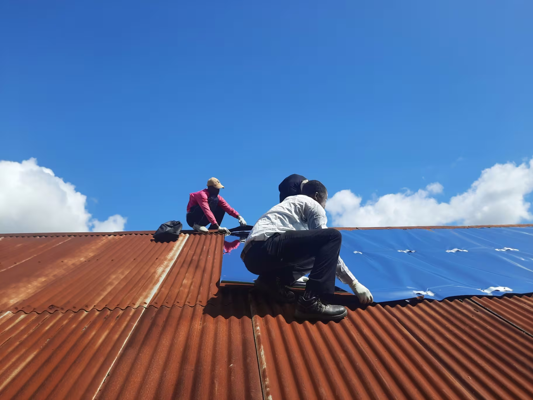 MEER team working across a large classroom roof in Dar es Salaam